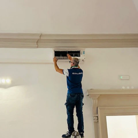 Calidra installazione e manutenzione condizionatori a Bologna Tecnico Calidra mentre effettua la pulizia dei filtri del condizionatore in un'abitazione a Bologna